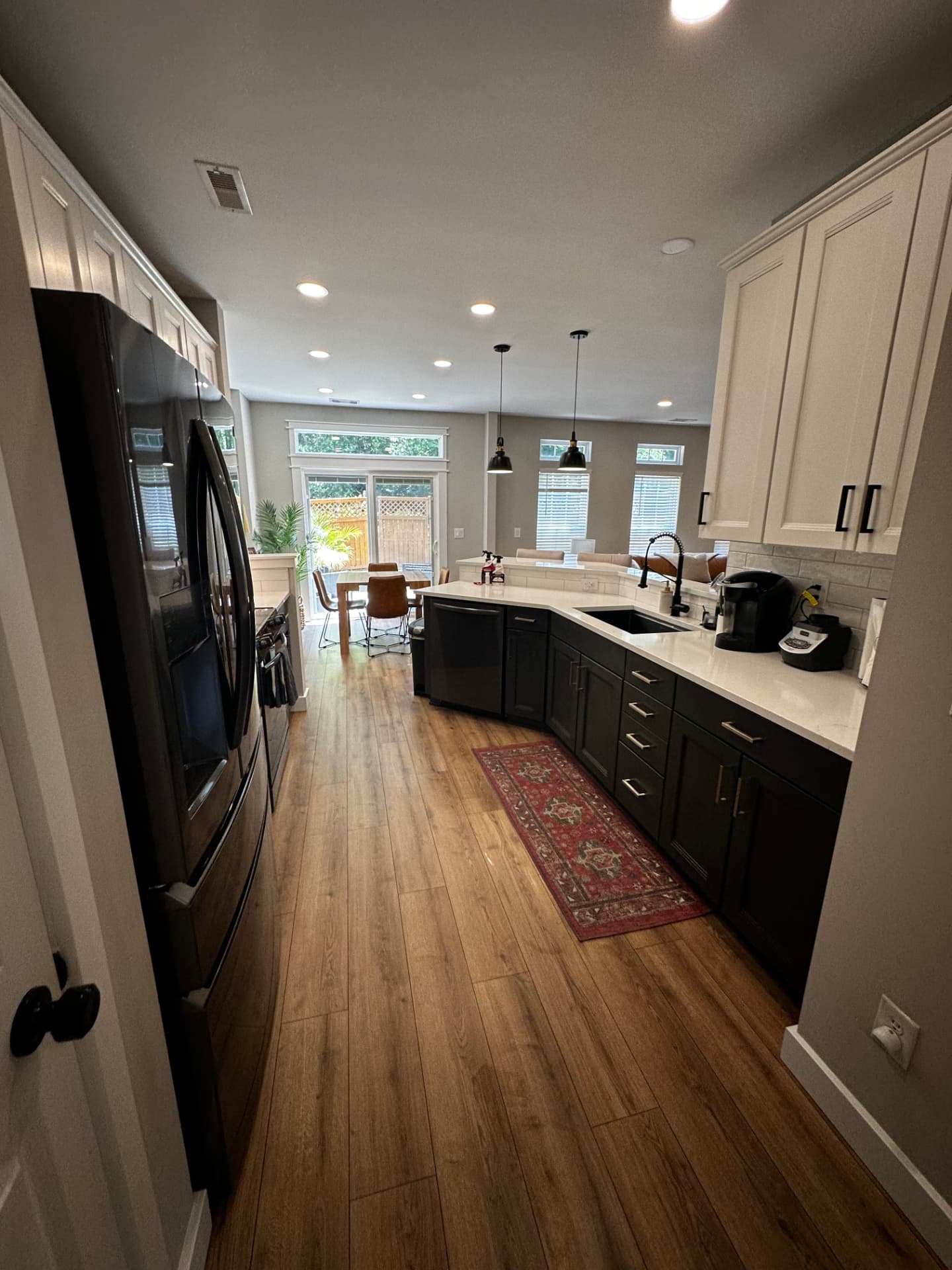 Open kitchen with clean countertops and mopped wood flooring